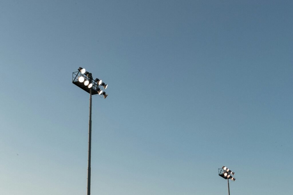 Stadium floodlights against an evening sky before a football game
