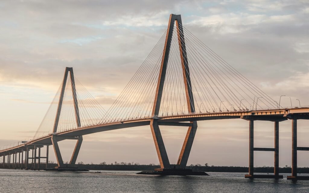 Arthur Ravenel Jr. Bridge's diamond towers and cables over the Cooper River under a soft sunset sky