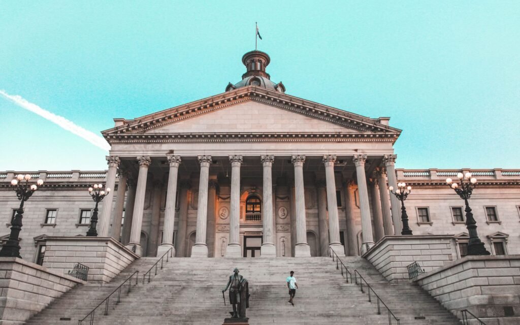 Front steps, columns and dome of the South Carolina State House in Columbia with a statue below