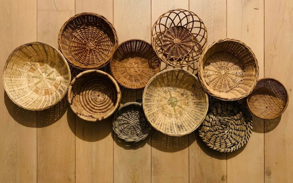 Round handwoven baskets of different sizes arranged on a light wooden floor