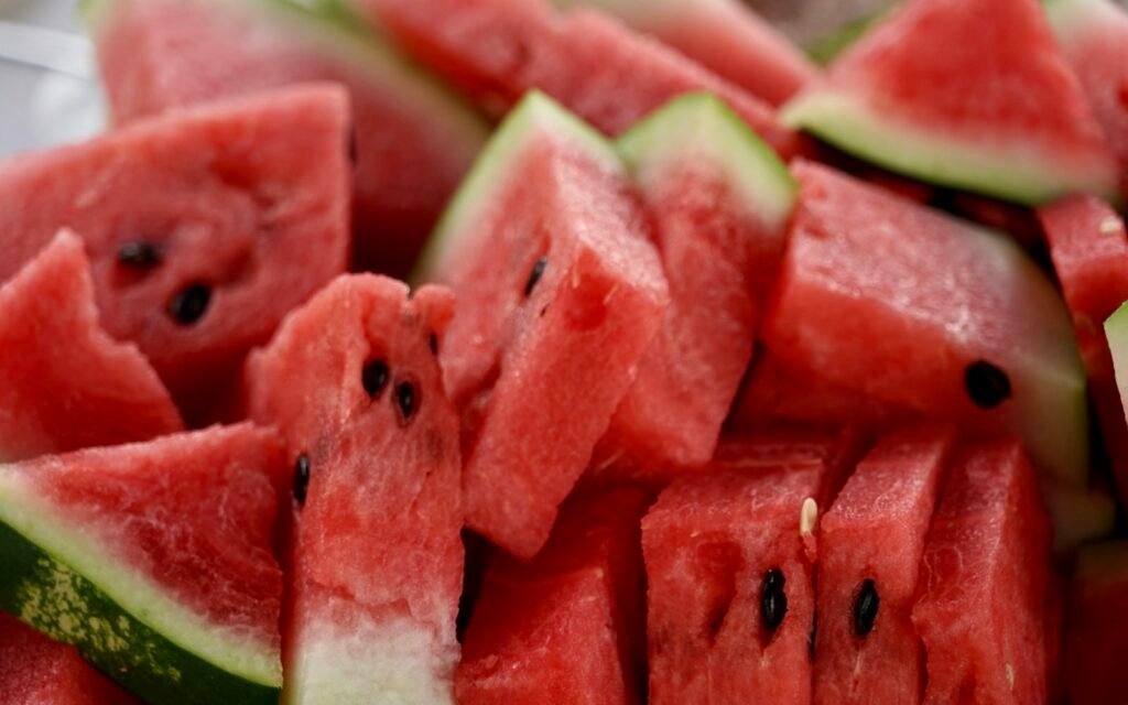 Close-up of juicy red watermelon slices and chunks with black seeds