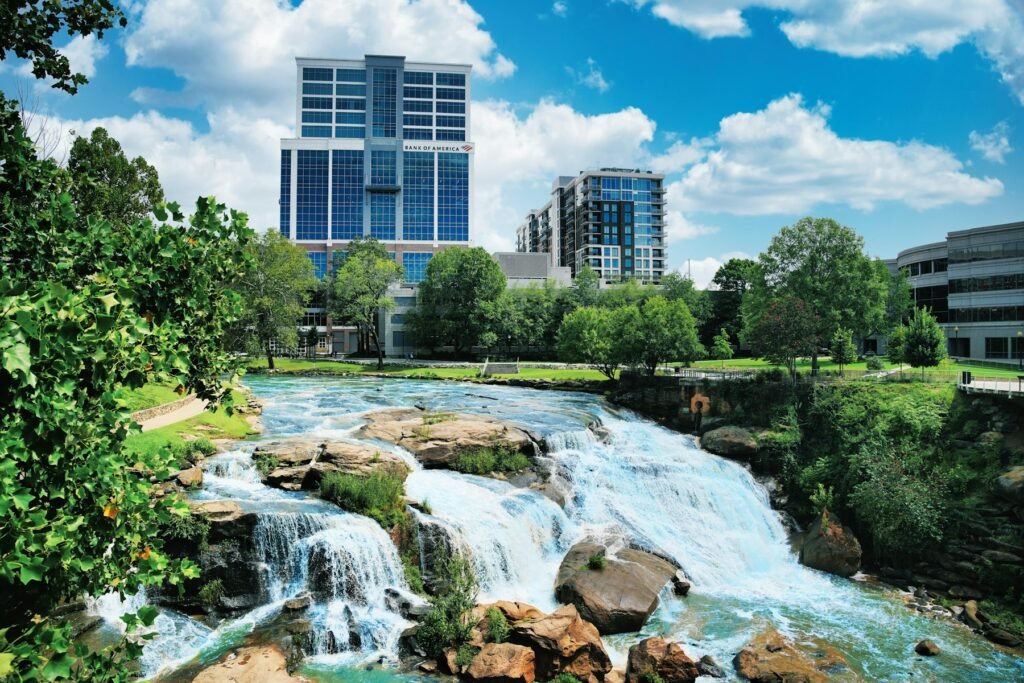 Waterfall tumbling over rocks in Falls Park on the Reedy with downtown Greenville towers behind