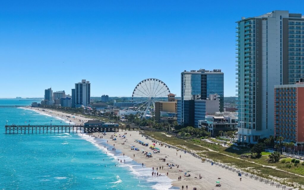 Aerial view of Myrtle Beach oceanfront with the SkyWheel, a fishing pier and high-rise hotels