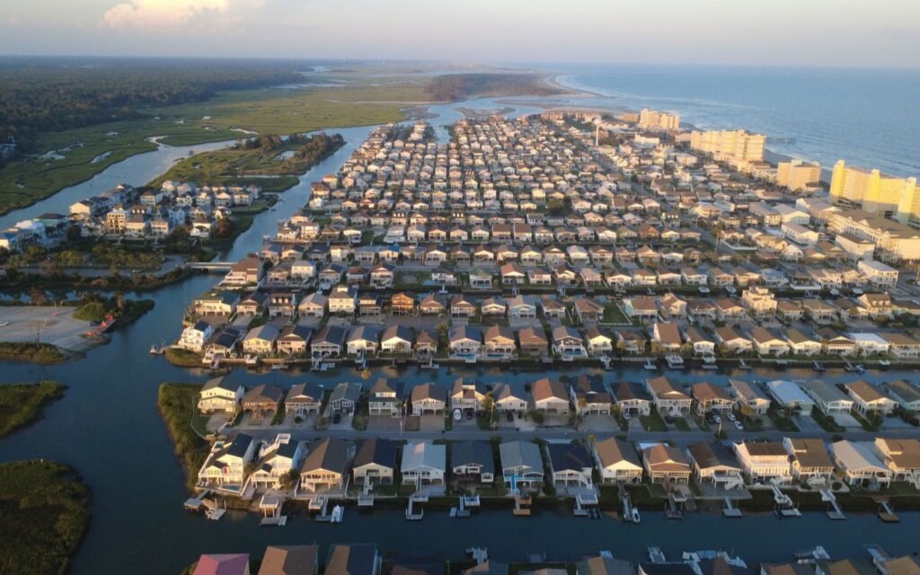 Aerial sunset view of Cherry Grove rows of beach houses between marsh channels and the ocean