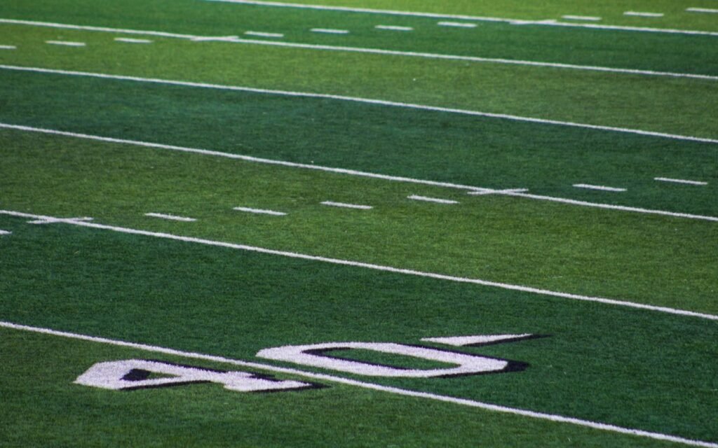 Green football field turf with white yard lines and a painted 40 yard marker