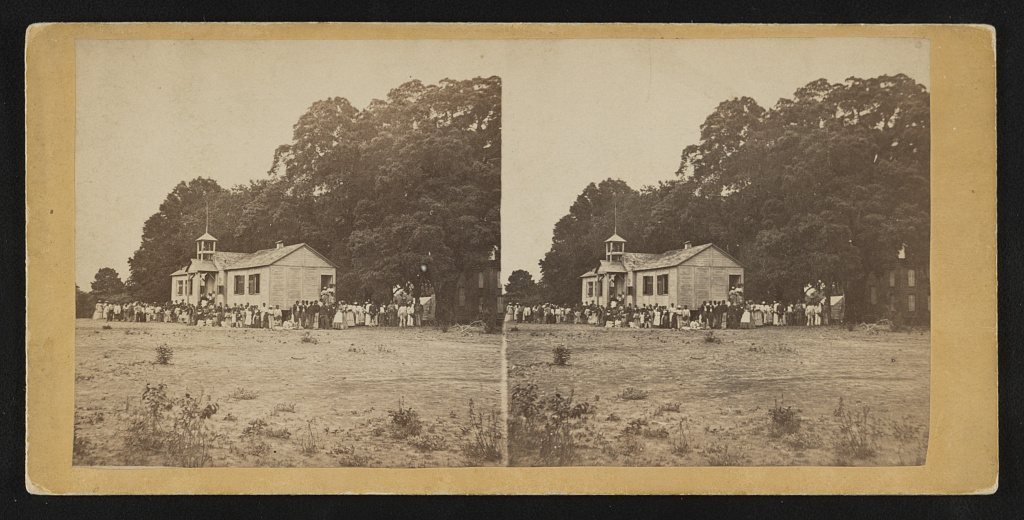 Stereograph of a crowd gathered in front of Miss Laura Towne's school building on St. Helena Island